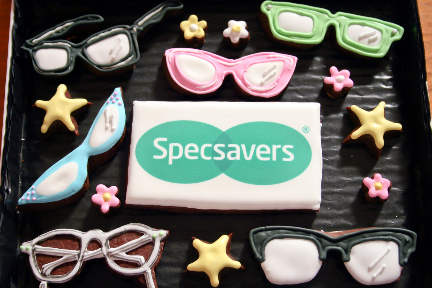 glasses cookies for supersavers. Specsavers corporate logo biscuits. Custom biscuit box with multicoloured glasses. Sepcsavers cookies and biscuits.