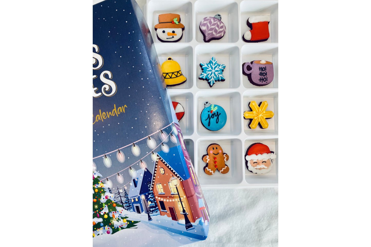 biscuit advent calendar. different hand iced Christmas biscuit bhind each door. count down to christmas with father christmas biscuit. snowman biscuit and gingerbread man biscuits