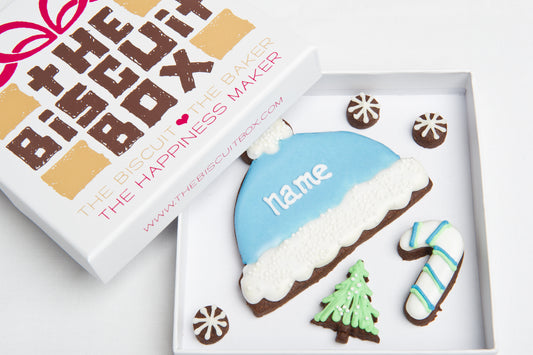 blue bobble hat with name iced onto it. personalised Christmas gift, iced hat biscuit. winter cookie idea.