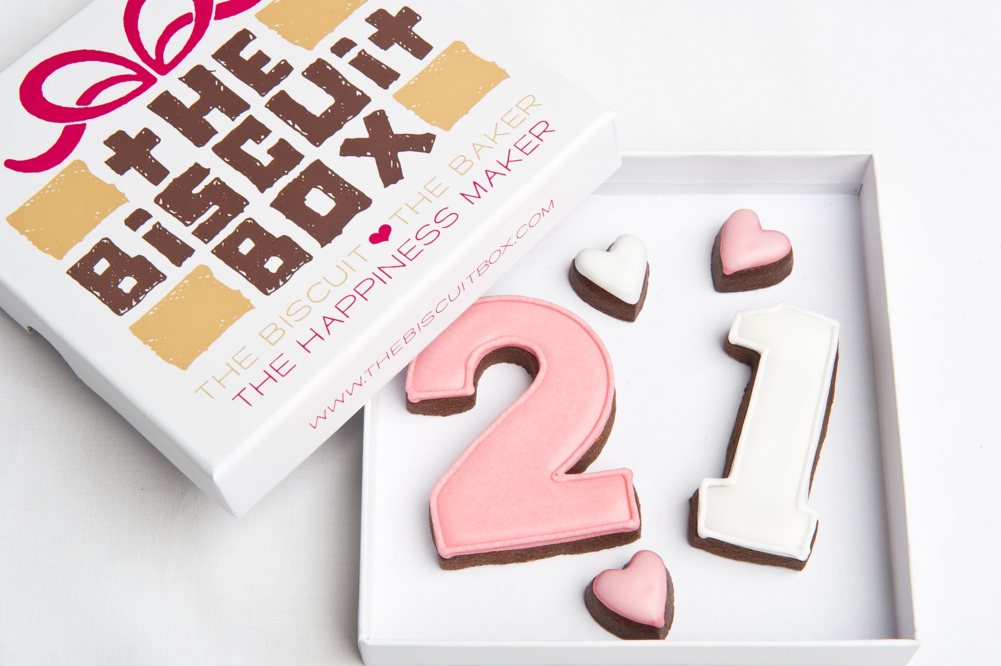 21st birthday biscuits. personalise any number in cookie shapes. Pink and white 21 birthday biscuits in a box with mini hearts.