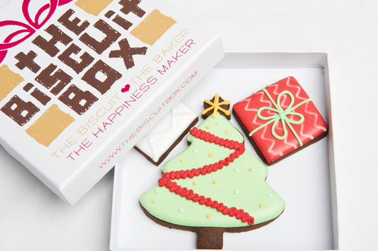 Christmas tree cookie iced in green with tinsel and bauble design. Christmas tree and present included in a small box that fits through a letterbox. Christmas cookie gift.