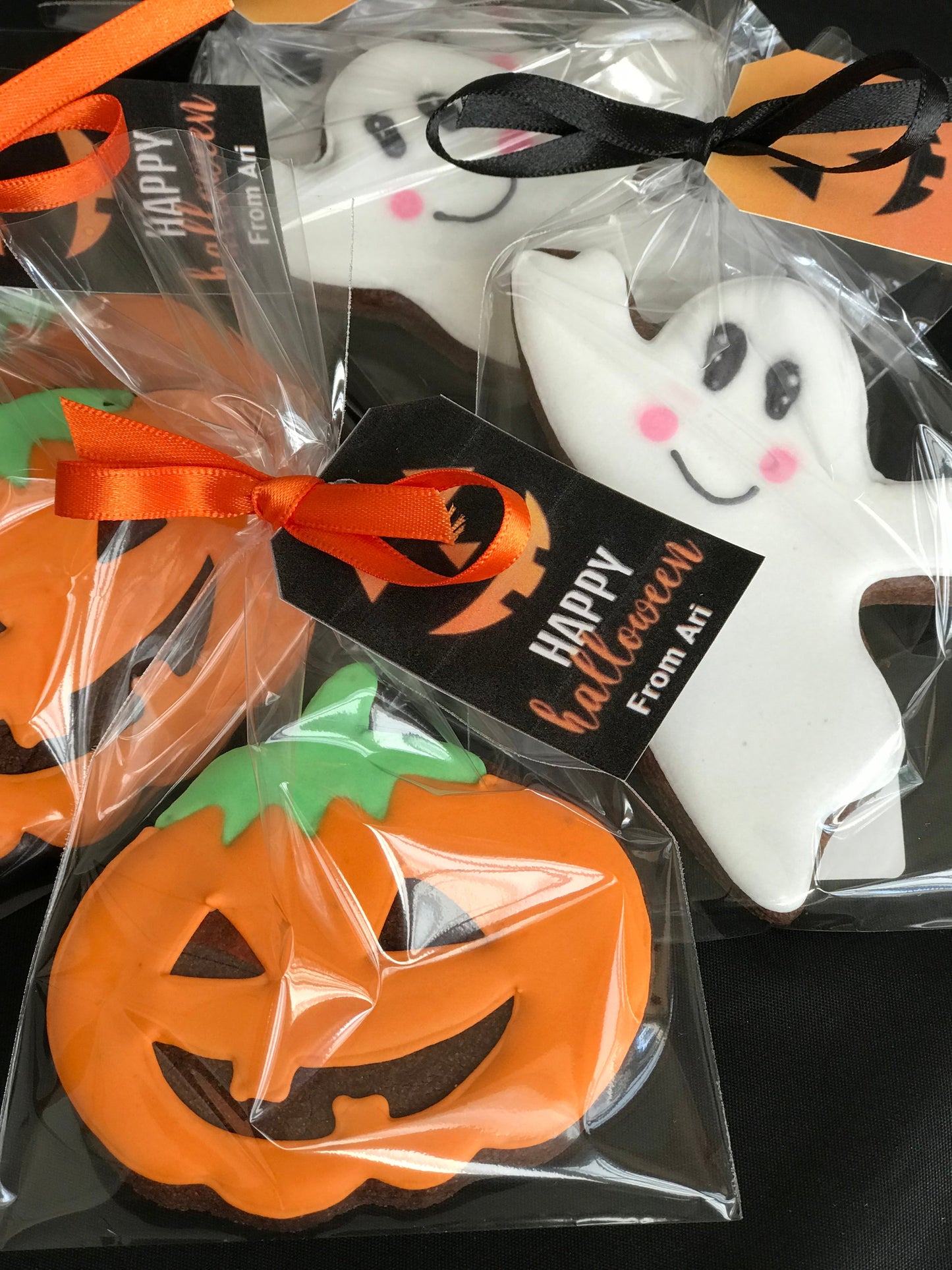 Halloween cookies individually wrapped and tied with ribbon.  Pumpkin cookie and ghost cookie.