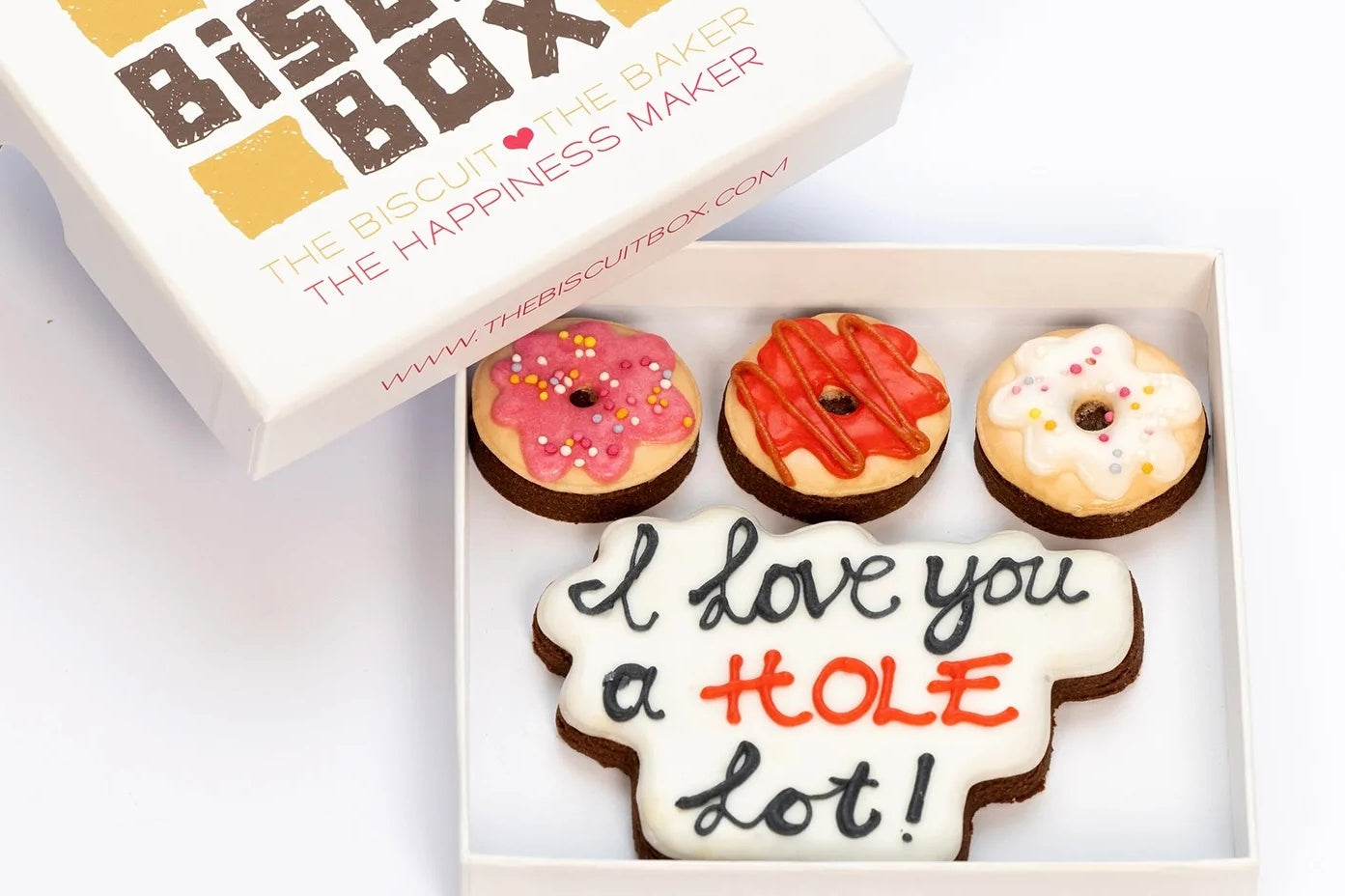 valentines day biscuits in the shape of min I doughnuts with text biscuit that says I love you a hole lot.