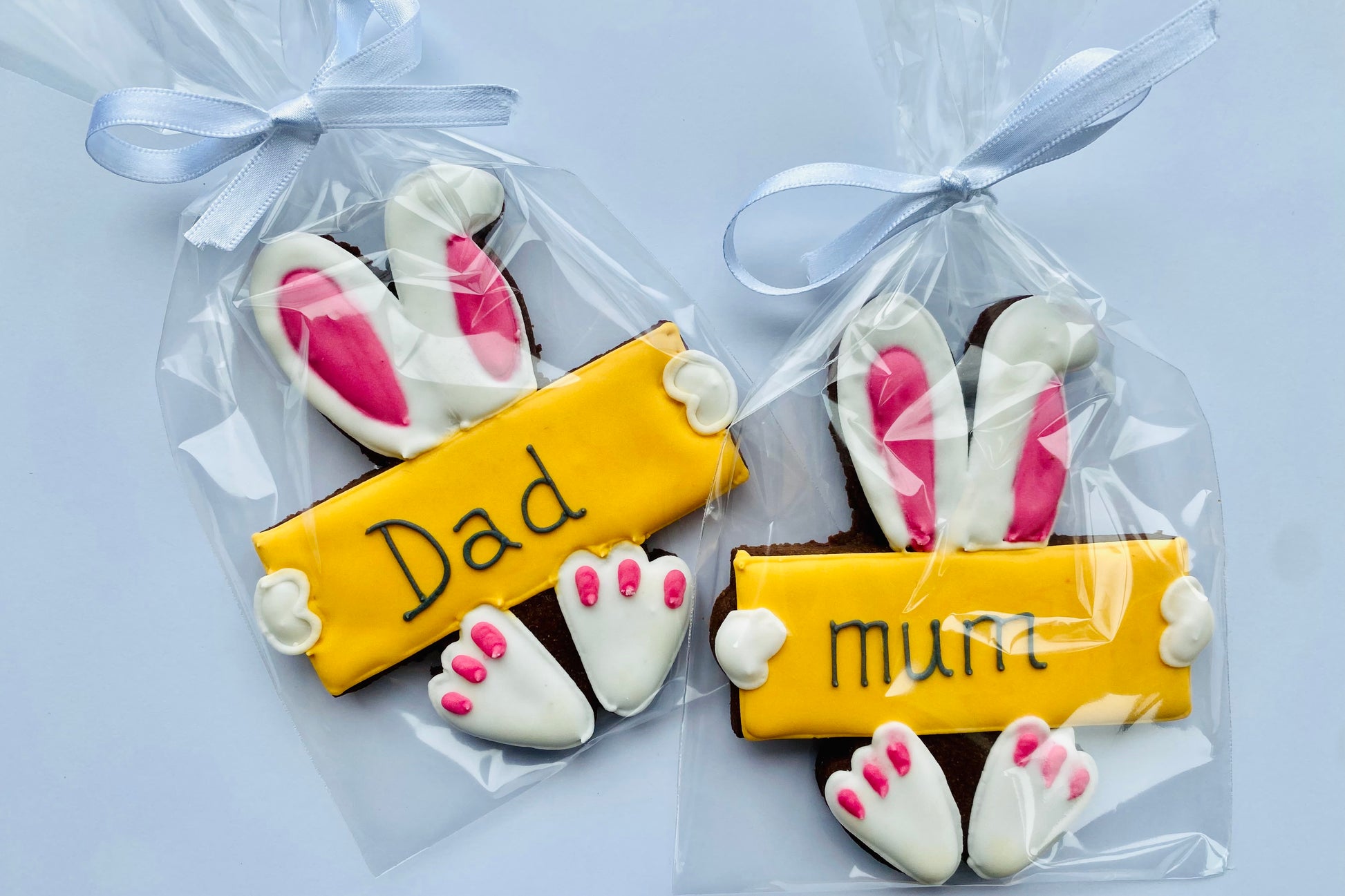 Easter place setting biscuits. Rabbit ears and feet with yellow iced plaque that can be personalised with an iced name perfect for an Easter table.