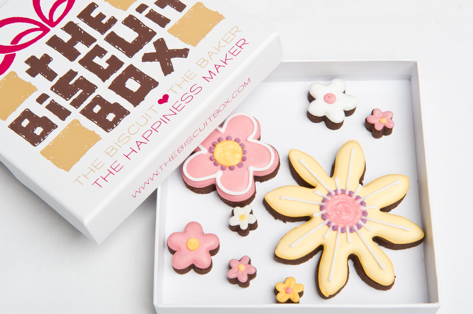 Flower cookies in a. box. Includes a yellow sunflower biscuit and a selection of colourful cookies in a. box.