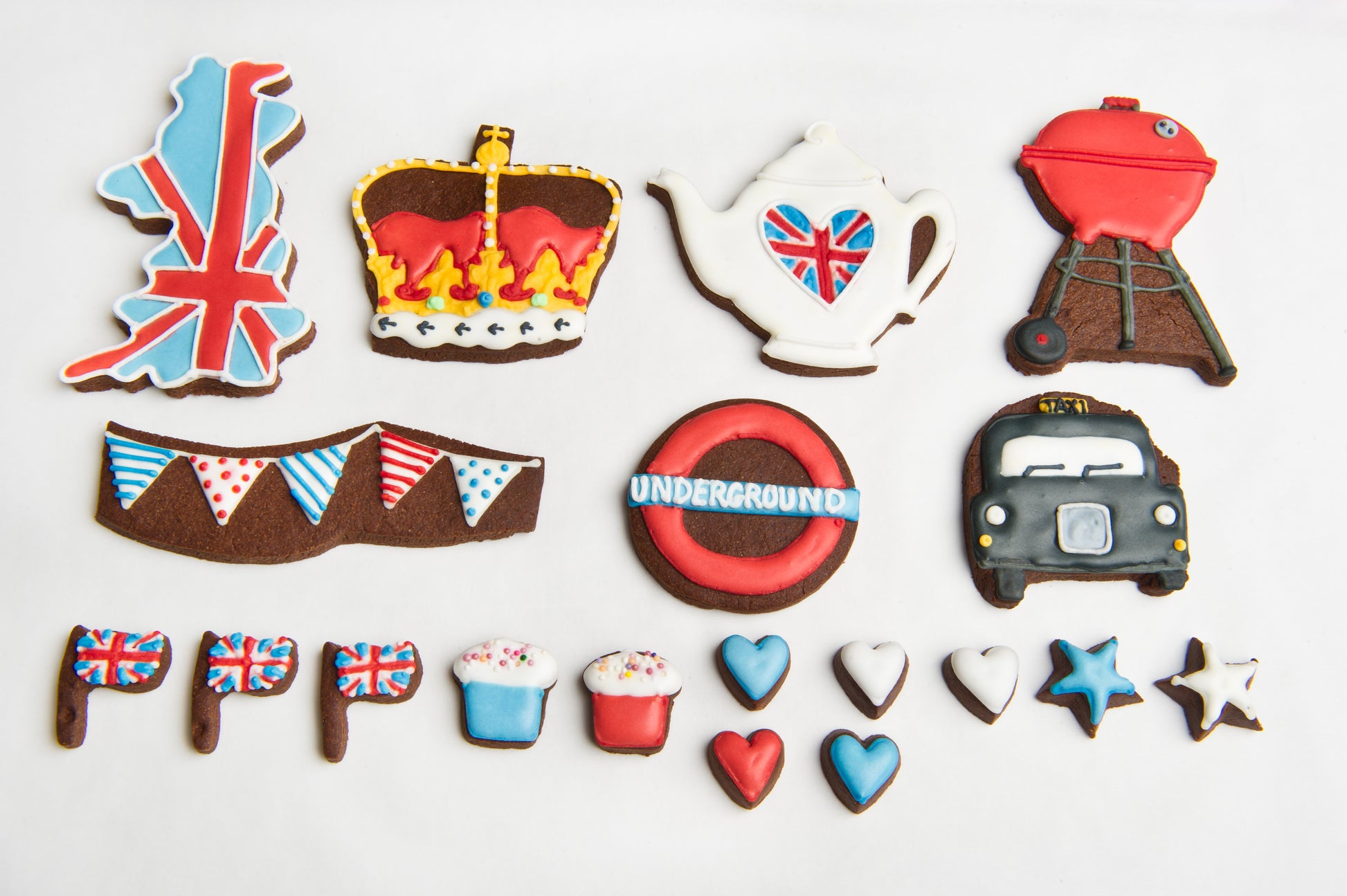 layout of the best of British biscuit tin. shows all biscuits in the tin. Union Jack biscuit. crown cookie. bunting cookies. bbq biscuits. London cookies taxi.
