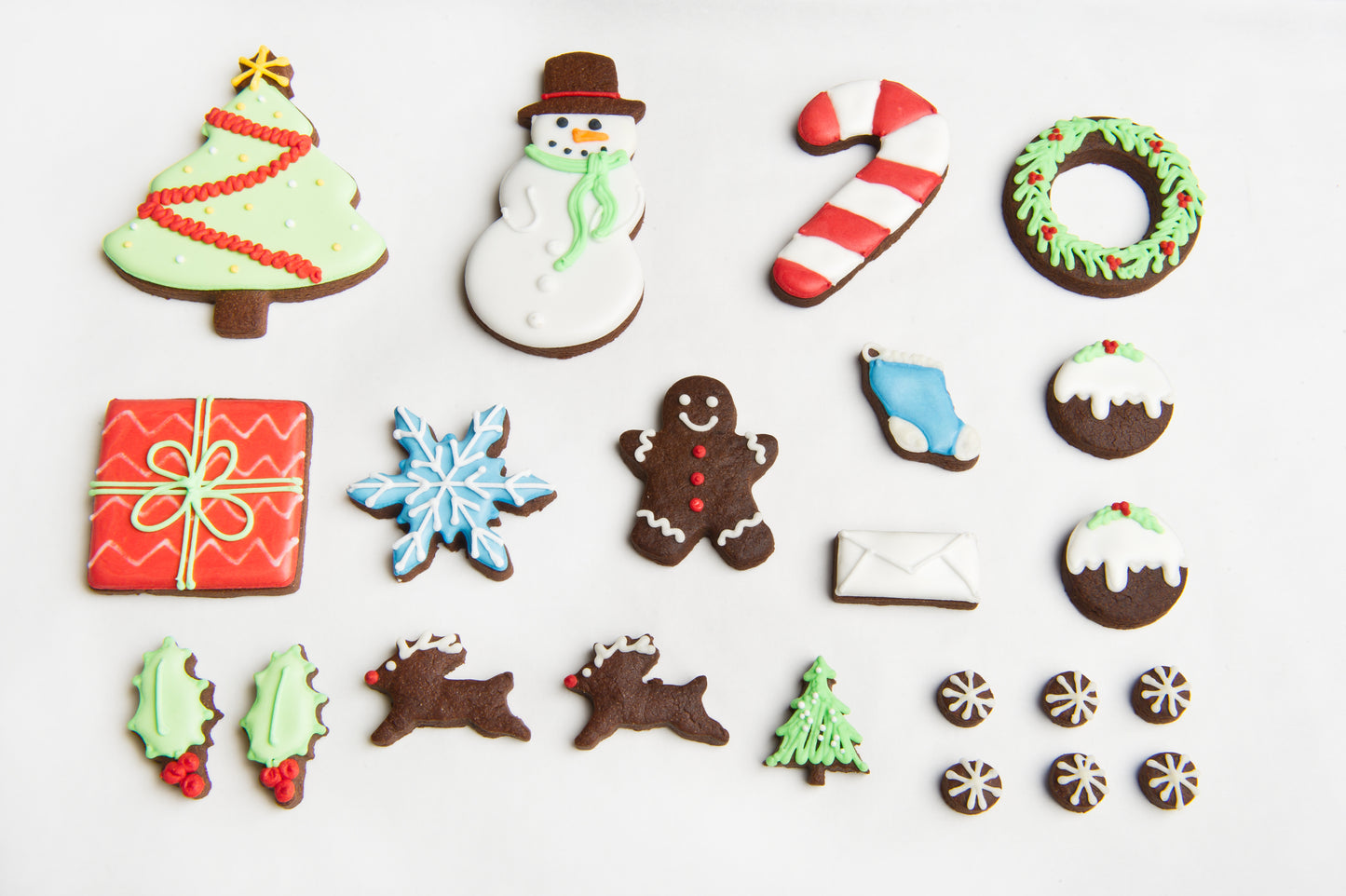 a layout to show the different biscuits included in the Christmas tin. Iced cookies include present, reindeer, snowman, Christmas tree, holly, wreath and mini snowflakes.