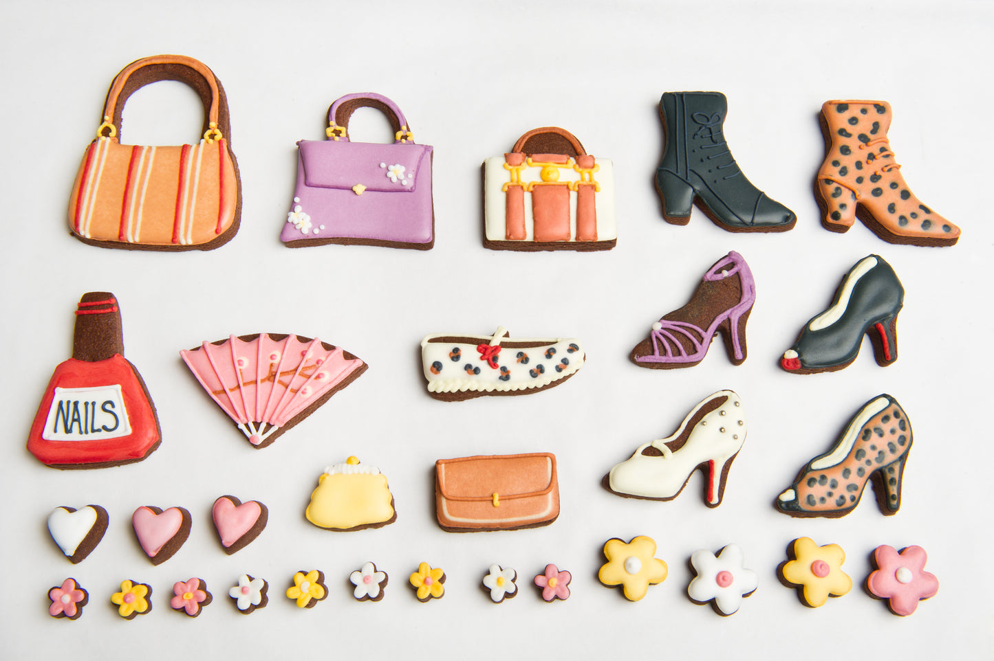 layout image of fashion biscuits included in the fashionista tin. handbag iced biscuits. Shoe cookies and iced cookies.
