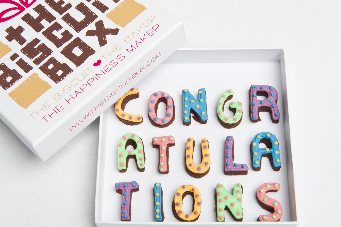 mini letter cookies that spell out congratulations. Congratulations biscuits iced in mulitcolour. Congratulations biscuit gift in box